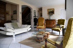 a living room with a white couch and chairs at Maison Marguerite in Bordères-Louron