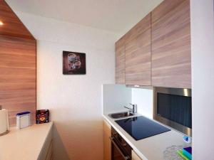 eine Küche mit einer Spüle und Holzschränken in der Unterkunft Fernblick Hohegeiß Sauna/Hallenbad in Hohegeiß