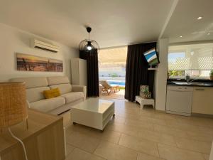 ein Wohnzimmer mit einem Sofa und einem Tisch in der Unterkunft Apartamento relax Tauro in Mogán