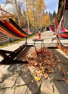 a patio with a table and a hammock and leaves at Old Mark's House Sinaia in Sinaia