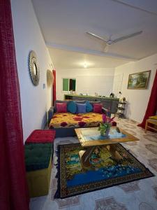 ein Wohnzimmer mit einem Bett und einem Tisch in der Unterkunft Appartement à 2 pas de l'ilôt de Sada. in Sada