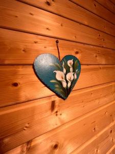 a heart shaped wall hanging on a wooden wall at Old Mark's House Sinaia in Sinaia
