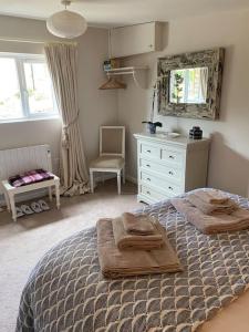 een slaapkamer met een bed met handdoeken erop bij Little Innsacre in Bridport
