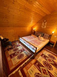 1 dormitorio con 1 cama en una cabaña de madera en Old Mark's House Sinaia en Sinaia