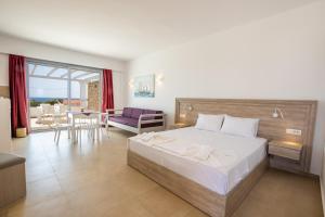 Bella Karpathos Villas في كارباثوس: غرفة نوم بسرير كبير وغرفة معيشة