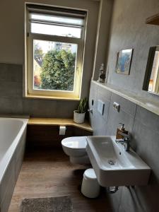 een badkamer met een toilet, een wastafel en een raam bij Ferienwohnung in der schönen Rattenfängerstadt in Hameln