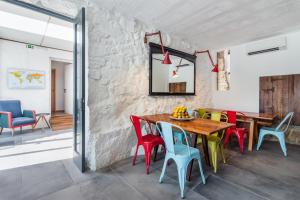 una sala da pranzo con tavolo in legno e sedie colorate. di Bridge It - Suites & Views a Vila Nova de Gaia