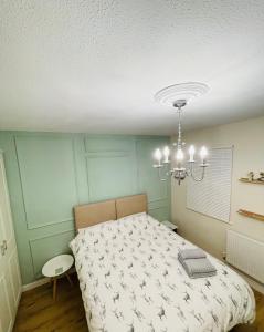 Schlafzimmer mit einem Bett und einem Kronleuchter in der Unterkunft Entire Home between London and Kent- Mulberry House in Kent