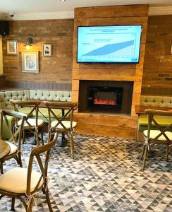 a restaurant with a fireplace and a tv on the wall at The Railway Crossings in Wingate