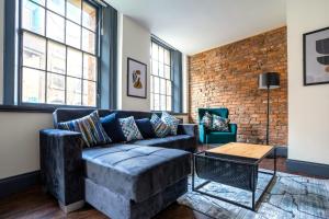 a living room with a couch and a brick wall at The Cavern Quarter Aparthotel by UStay in Liverpool