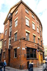 a brick building with people standing outside of it at The Cavern Quarter Aparthotel by UStay in Liverpool