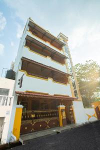 a tall building with a yellow and white at Sri Balaji Villas in Puducherry