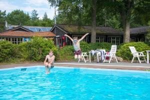two children jumping into a swimming pool at EuroParcs De Wiltzangh in Ruinen