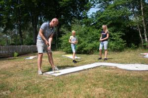 a man and two women standing in a yard playing a game at EuroParcs De Wiltzangh in Ruinen