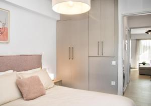 um quarto com uma cama branca e um closet em Sia Mare em Kalívia Thorikoú