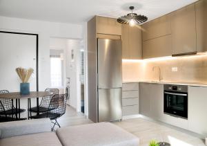 a kitchen with a stainless steel refrigerator and a table at Sia Mare in Kalívia Thorikoú