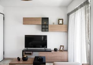 a living room with a flat screen tv on a wall at Sia Mare in Kalívia Thorikoú
