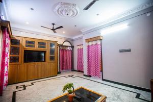 sala de estar con TV y mesa en Sri Balaji Villas en Pondicherry