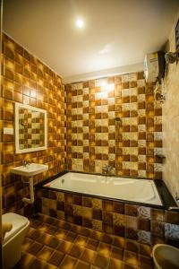 a bathroom with a tub and a toilet and a sink at Sri Balaji Villas in Puducherry