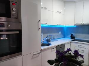 una cocina con armarios blancos y fregadero en Agape apartman en Višegrad