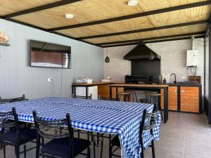 cocina con mesa y sillas azules y blancas en CASA con quincho, piscina y tinaja, Playa San Alfonso y Laguna, en Algarrobo