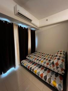 a small bedroom with a bed in front of the window at Lovely 1BR Condo @ SM Southmall w/ Netflix & High Speed WIFI in Manila