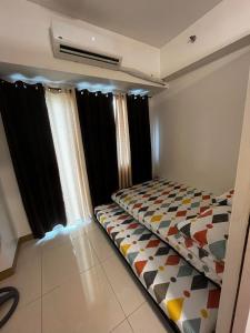 a bed in a room with black curtains at Lovely 1BR Condo @ SM Southmall w/ Netflix & High Speed WIFI in Manila
