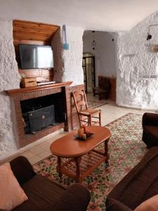 sala de estar con mesa y chimenea en Cuevas Baza, en Baza