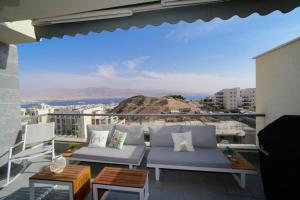 a balcony with chairs and a view of the city at Gorgeous - Red rock and Sea view. in Eilat