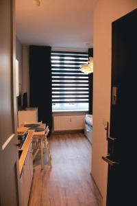 *Apartamenty Kattowitz 12 في كاتوفيسي: غرفة مع مطبخ مع طاولة ونافذة