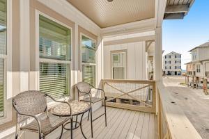 a porch with two chairs and a table and some windows at Cool Breeze in Gulf Shores