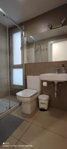 a bathroom with a toilet and a sink and a mirror at Las Canteras OP2 in Las Palmas de Gran Canaria