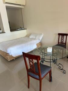 Schlafzimmer mit einem Bett, einem Glastisch und einem Stuhl in der Unterkunft Palm resort 2B in Sharm El Sheikh