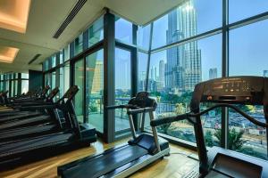 einen Fitnessraum mit Blick auf die Skyline der Stadt in der Unterkunft Magnificent Stunning 2 BR Apartment with Burj Khalifa View in Dubai