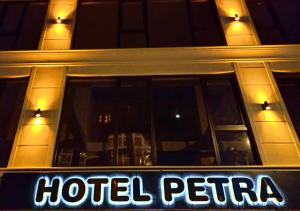 um sinal hoteleria em frente a um edifício à noite em PETRA HOTEL TUZLA em Tuzla
