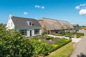 a house with a garden in front of a street at Boerderijwoning in Serooskerke