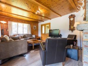 a living room with a couch and a tv at Beautiful holiday home in Fieschertal with garden in Fieschertal