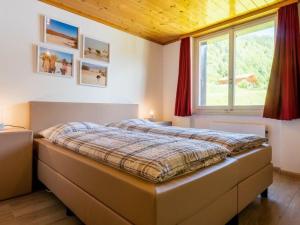 ein Schlafzimmer mit einem Bett in einem Zimmer mit einem Fenster in der Unterkunft Beautiful holiday home in Fieschertal with garden in Fieschertal