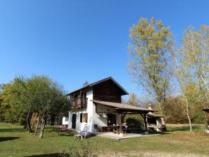 ein Haus mit einer Veranda auf einem Feld mit Bäumen in der Unterkunft Secluded holiday home in Borgo Valbelluna with garden 
