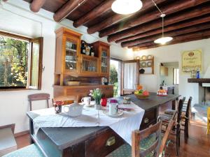 una cucina con tavolo e tovaglia bianca di Secluded holiday home in Borgo Valbelluna with garden 