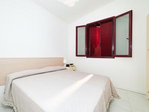 a white bedroom with a bed and a window at Inviting holiday home in Altidona with solarium in Pedaso