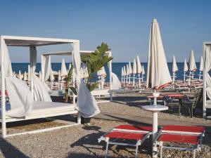 un gruppo di sedie e ombrelloni in spiaggia di Inviting holiday home in Altidona with solarium a Pedaso