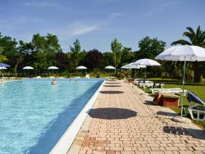 una grande piscina con ombrelloni e sedie di Inviting holiday home in Altidona with solarium a Pedaso