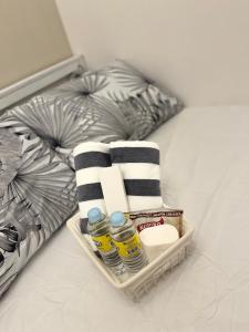 a basket with towels and other items on a bed at Posh 1BR @ SM Southmall w/ 100mbps and Netflix in Manila +5 photos
