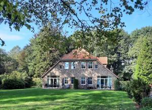 stary kamienny dom na zielonym trawniku w obiekcie Forsthaus Gödens w mieście Friedeburg