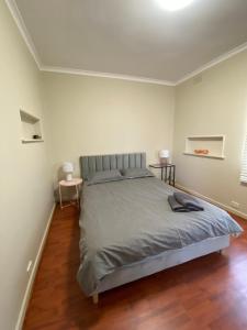 1 dormitorio con 1 cama grande y suelo de madera en Mitcham Station Home Stay, en Mitcham