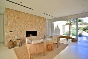 a living room with a stone wall with a fireplace at Contemporary Ibizan Villa Cala Conta Dream Short Walk to Beach San Jose in Cala Comte