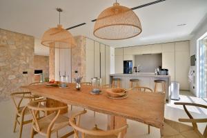 a kitchen and dining room with a wooden table and chairs at Contemporary Ibizan Villa Cala Conta Dream Short Walk to Beach San Jose in Cala Comte