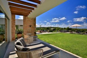 an outdoor patio with chairs and a lawn at Contemporary Ibizan Villa Cala Conta Dream Short Walk to Beach San Jose in Cala Comte
