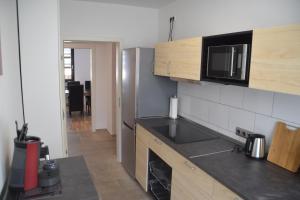 eine Küche mit schwarzer Arbeitsplatte und Holzschränken in der Unterkunft Ruhrbetten in Gelsenkirchen + 9 Fotos